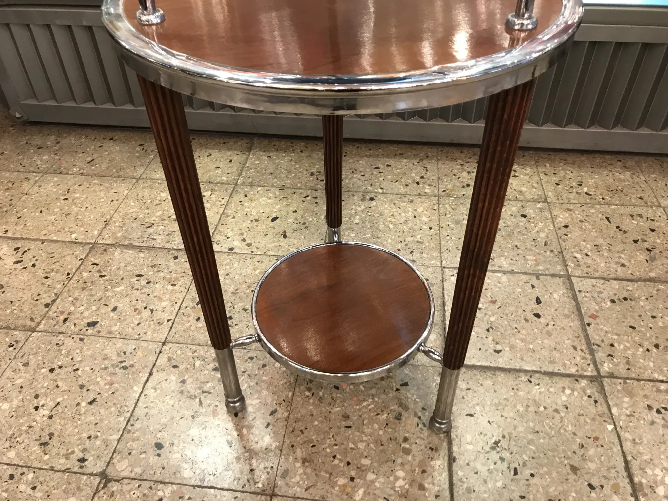 Petite table antique ronde à deux niveaux, dans un cadre classique.