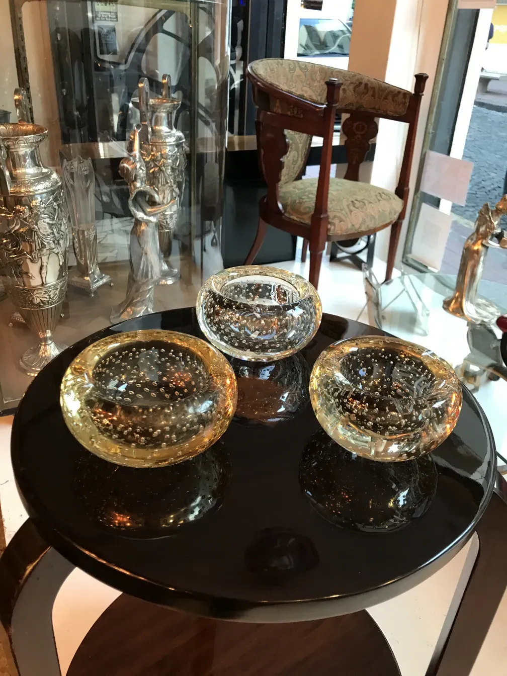 Tavolino antico nero con forme eleganti e ciotole decorative