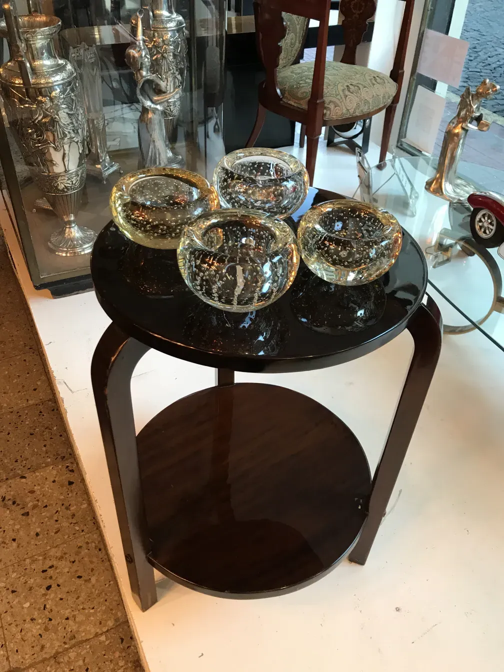 Antike kleine Tisch mit minimalistischem Design und subtilen Dekorationen, begleitet von dekorativen Gläsern.