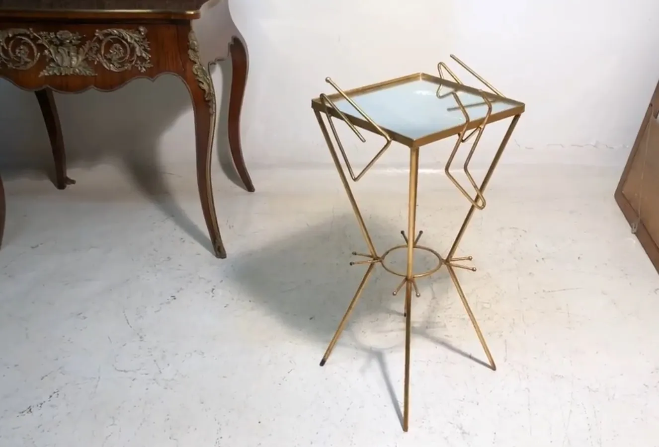 Small antique table with slender legs in a vintage setting.