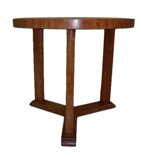 Tavolino antico rotondo con gambe robuste in un ambiente neutro.