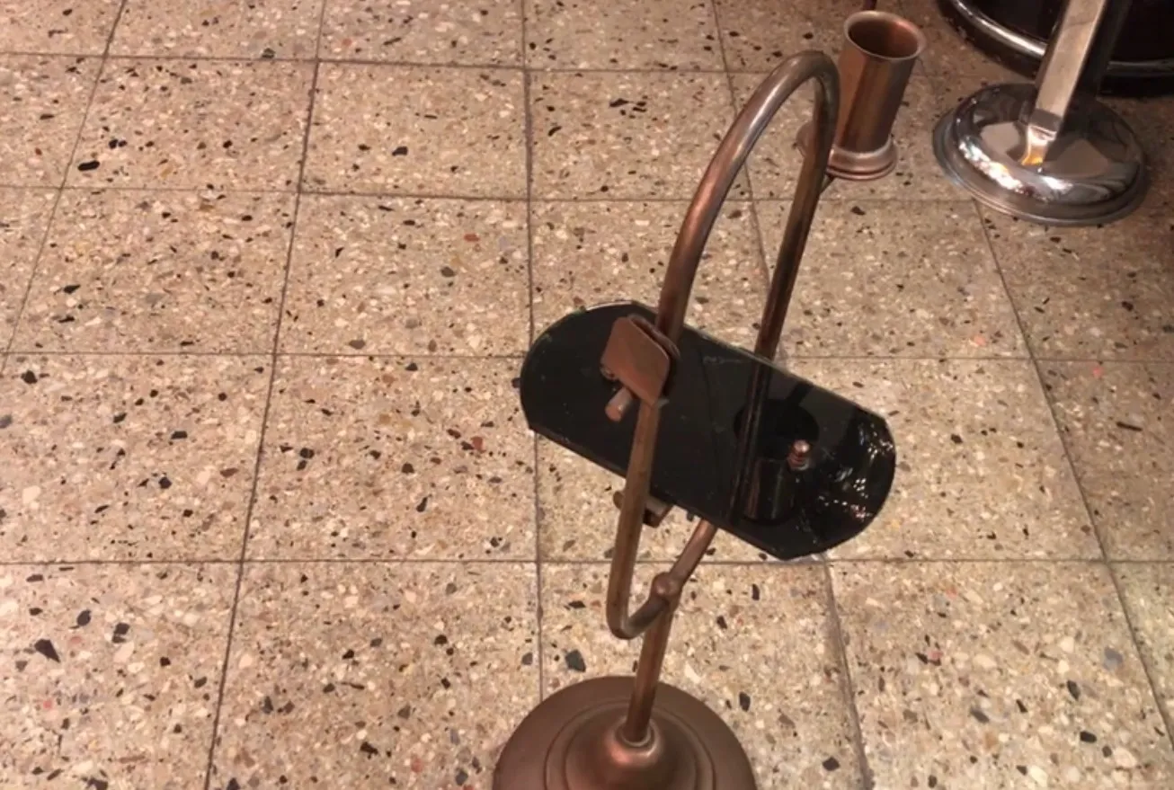 Mesita antigua con diseño único y soporte curvado en ambiente clásico.