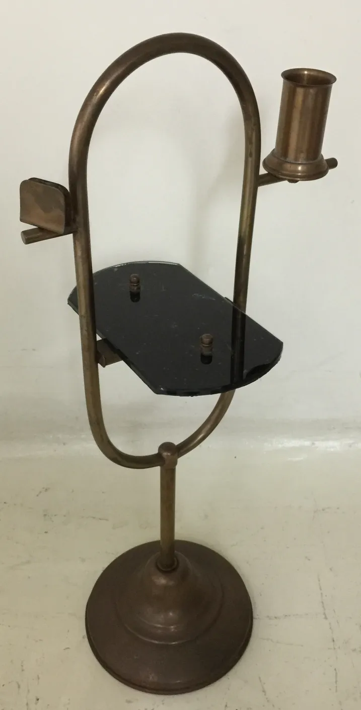 Petite table antique avec un support pour bougie, couleur bronze.