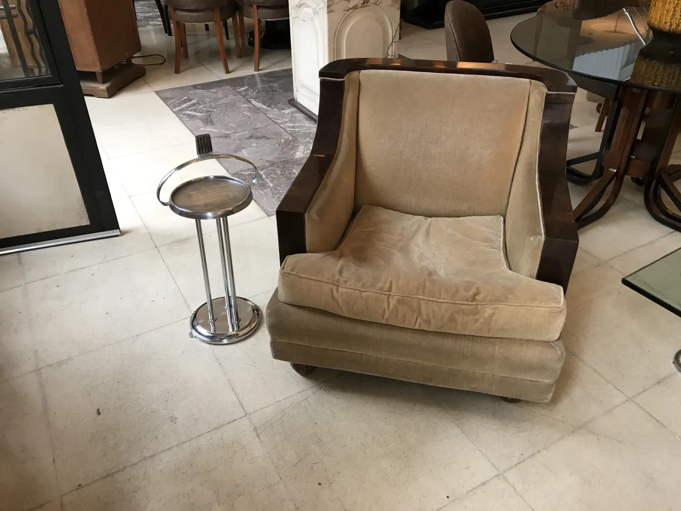 mesita antigua pequeña junto a un sillón cómodo