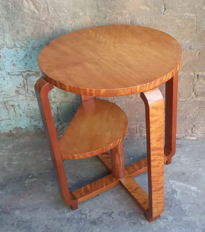 petite table antique ronde avec une étagère décorative, fond clair