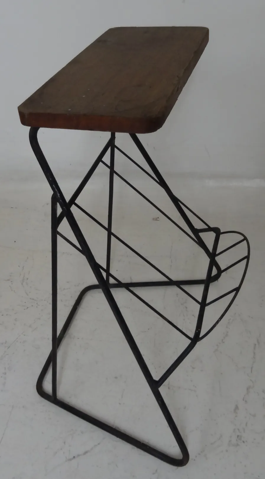 Mesita antigua con un diseño simple y patas de metal, fondo blanco.