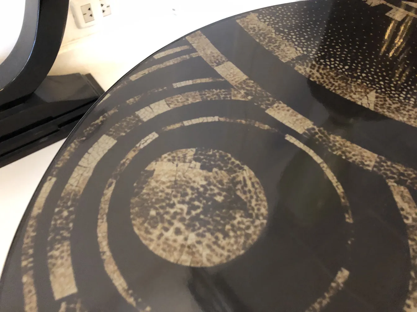 Antico tavolino con motivo geometrico sulla parte superiore.