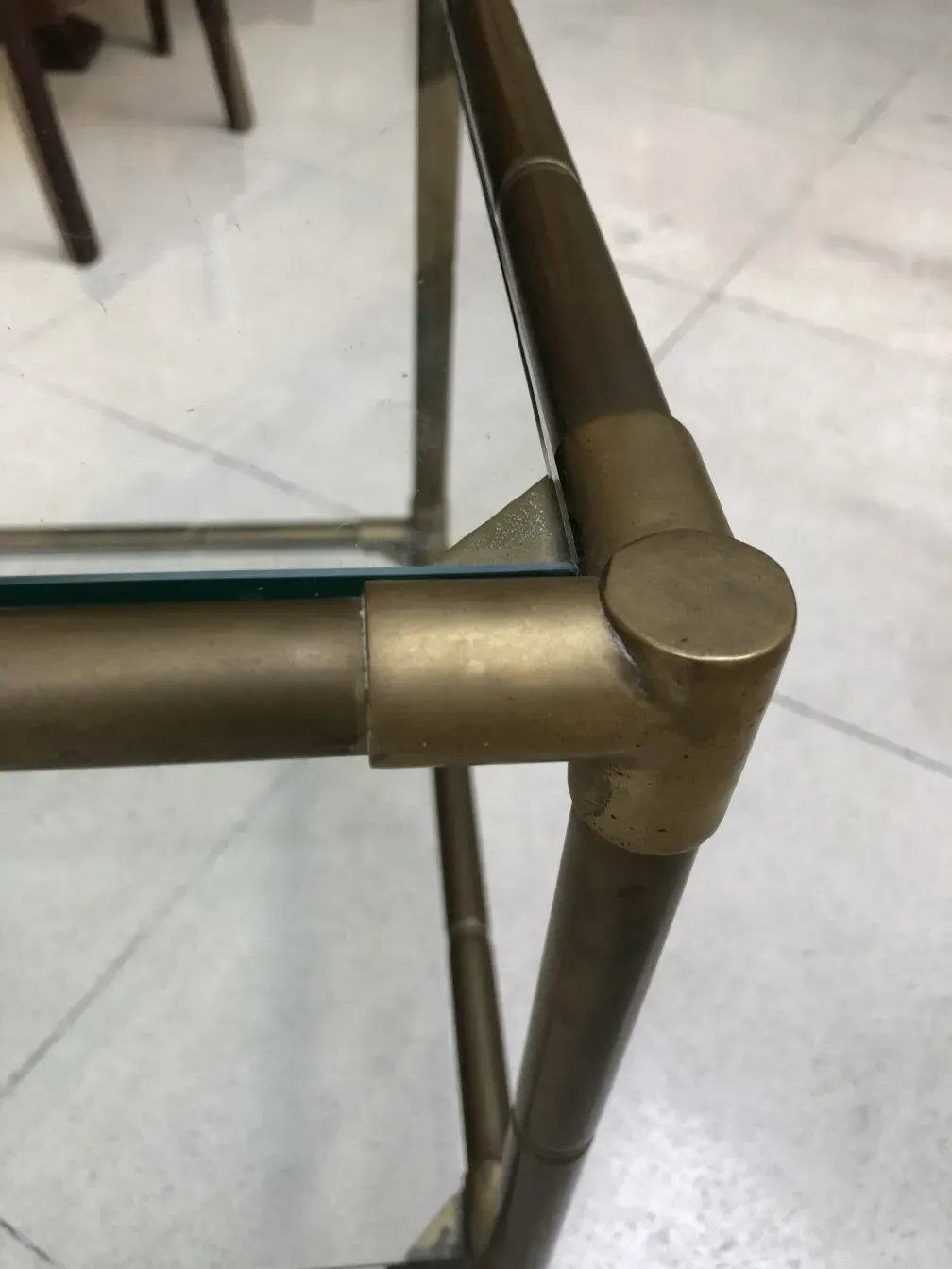 Mesinha antiga com pernas metálicas e design simples.