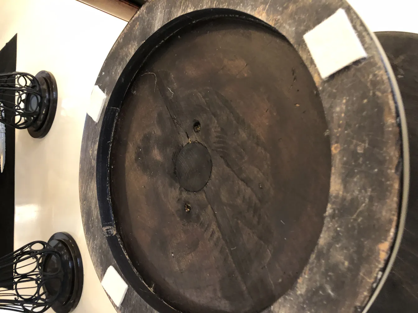 Mesita antigua con detalle en la parte superior, rodeada de un ambiente acogedor.