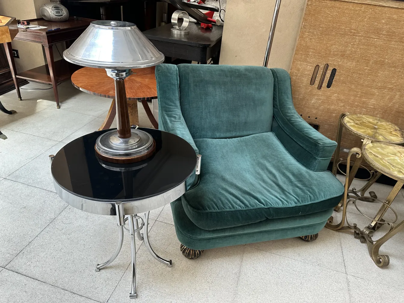 Tavolino antico con lampada, colore nero e argento, in un ambiente accogliente.