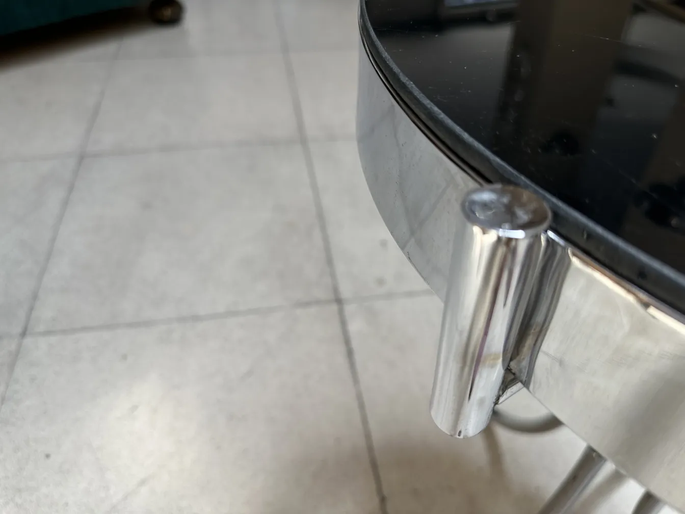 Ancienne petite table ronde avec détails en relief, dans un environnement neutre