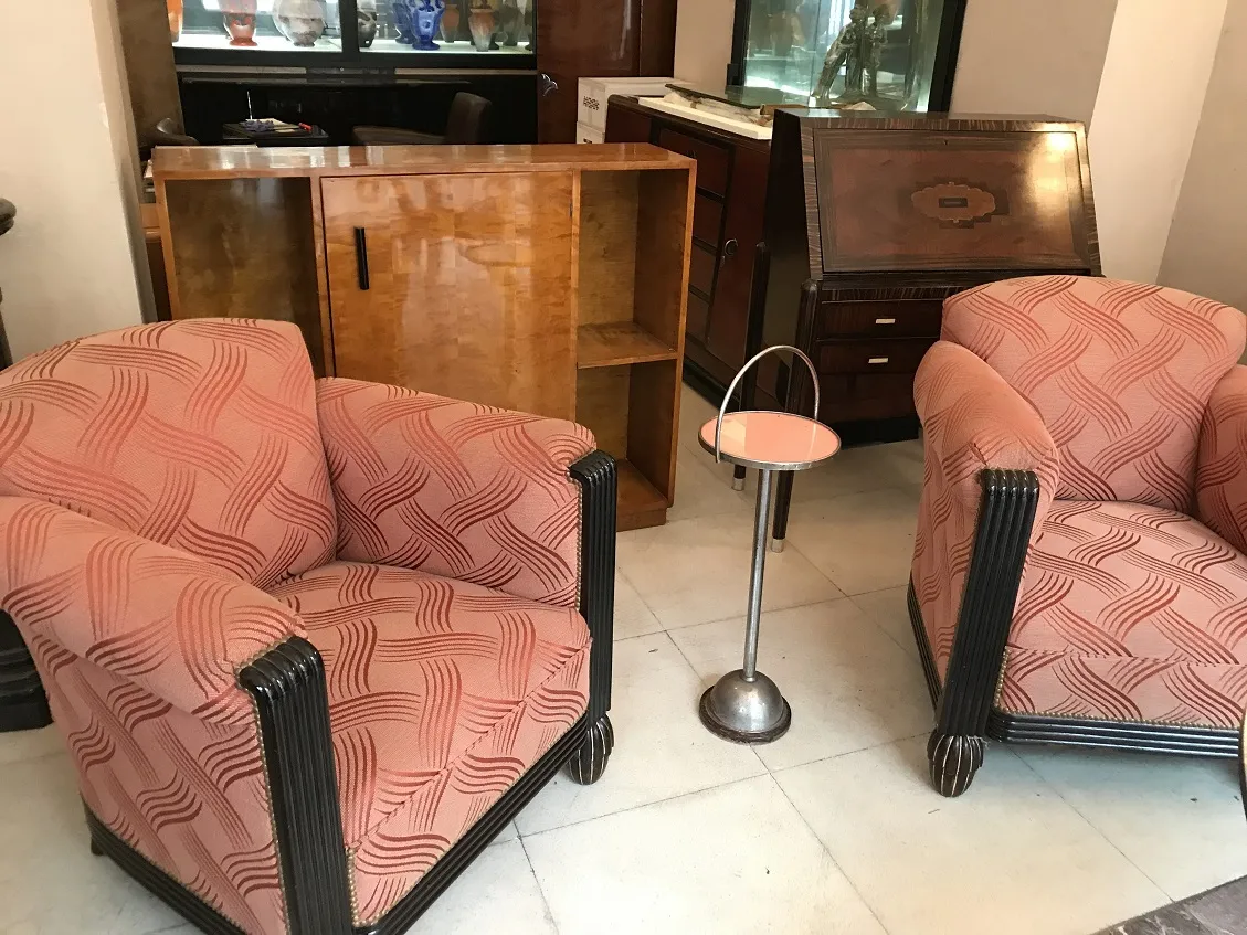 Antiker kleiner Tisch neben Sesseln in klassischem Ambiente