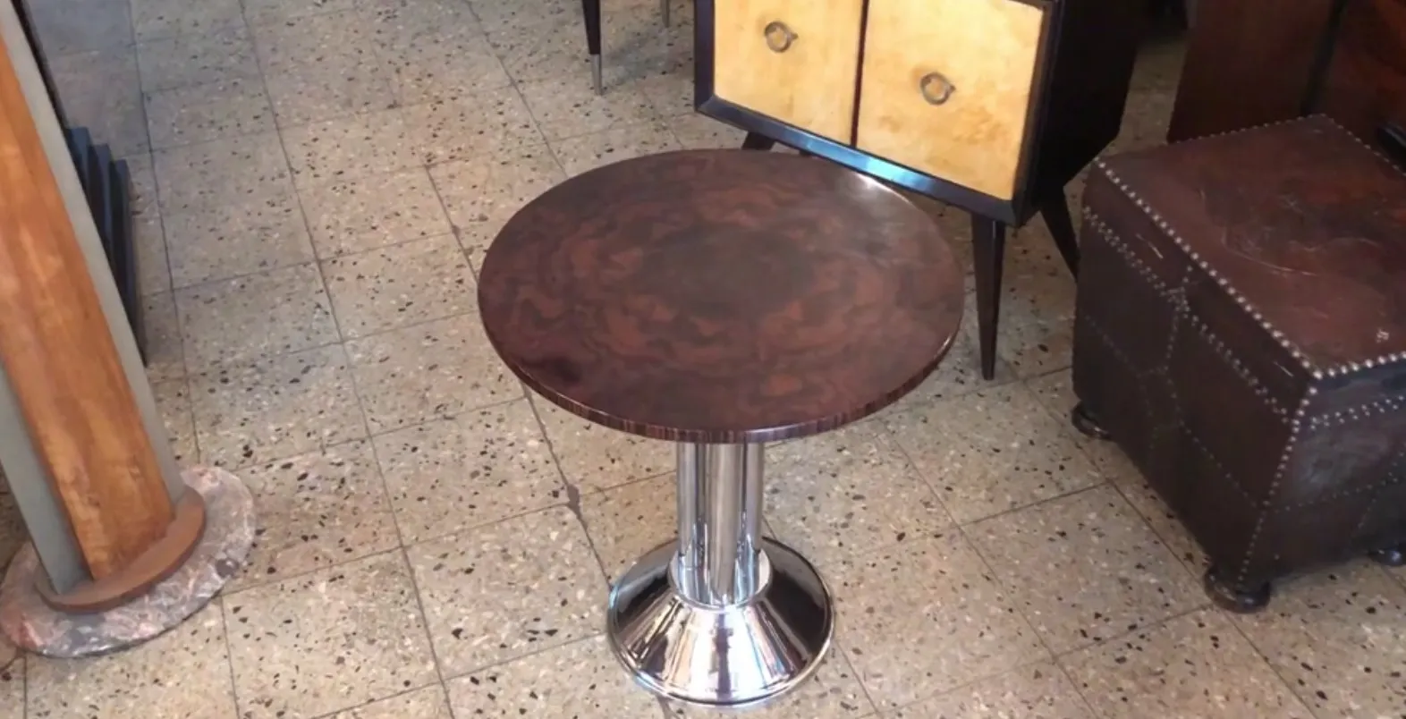 petite table antique ronde avec base argentée et surface lisse dans un cadre accueillant