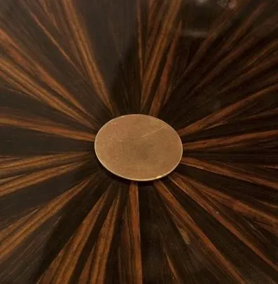 Petite table ancienne avec un design rayonnant de teintes sombres.