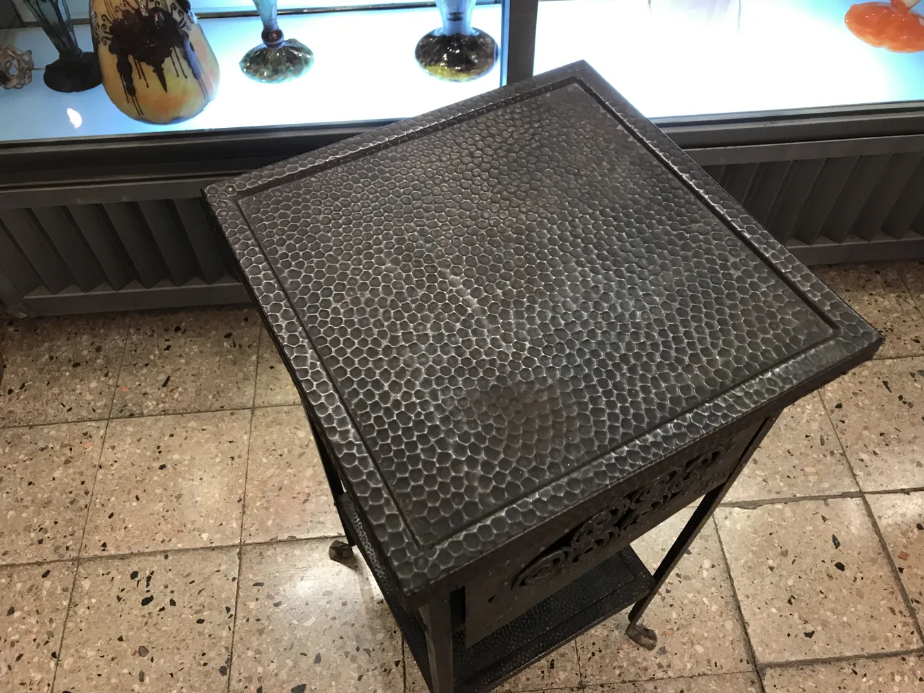 Antique small table with textured surface in a decorative setting.