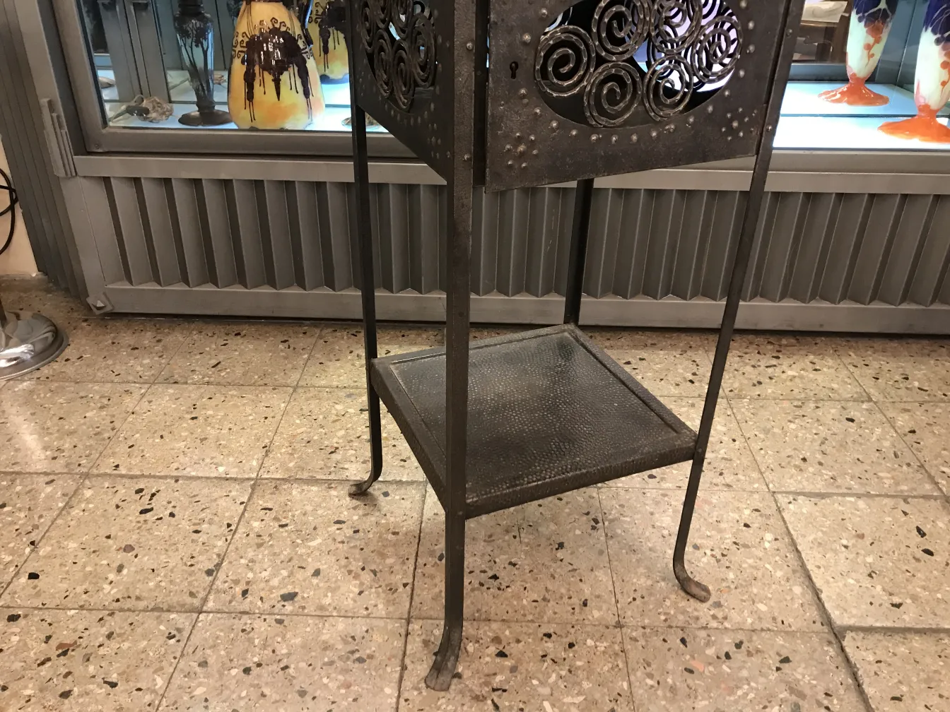 Tavolino antico con dettagli in rilievo, collocato in un ambiente antico.