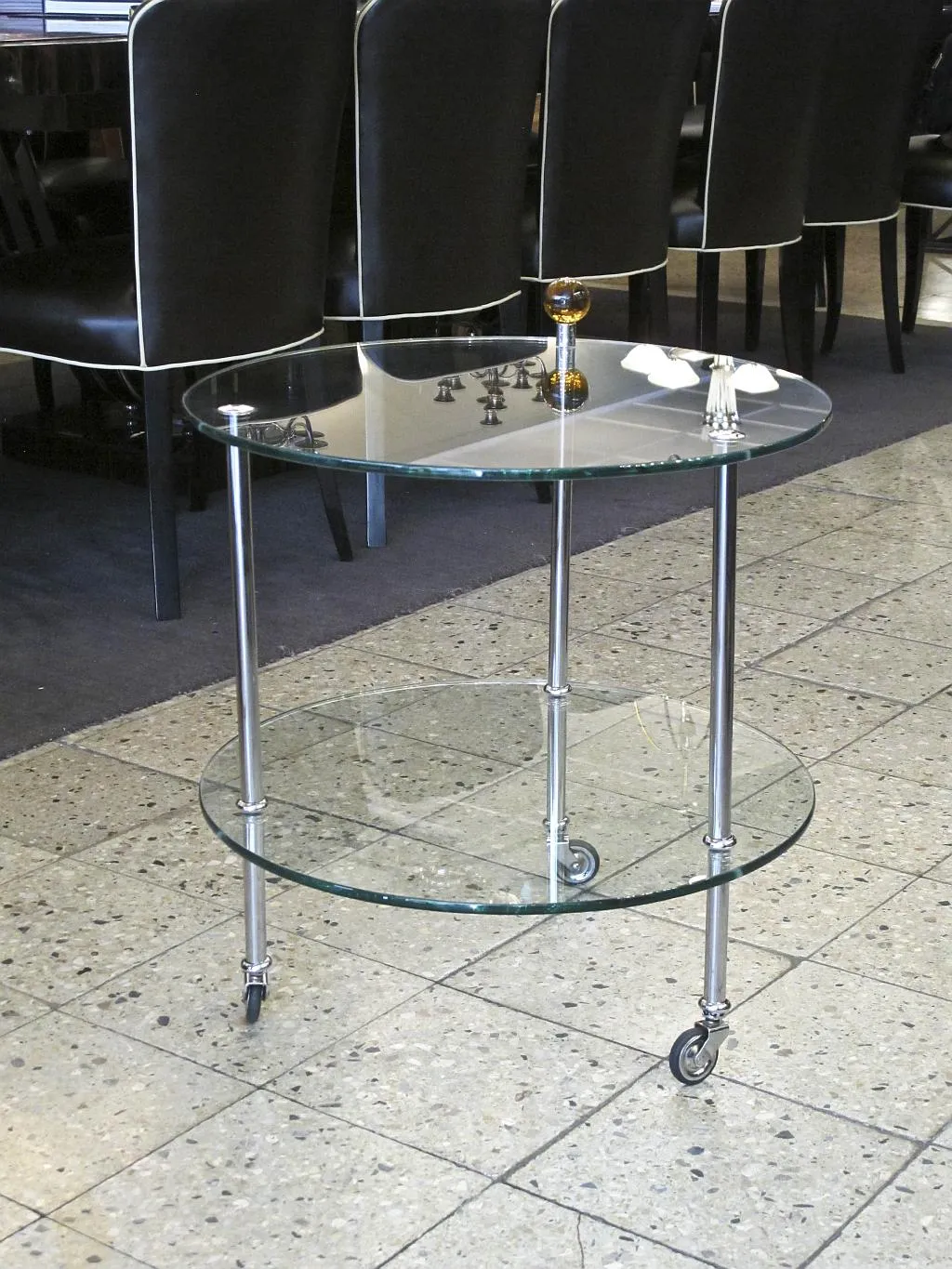 Petite table ancienne à deux niveaux avec dessus en verre et roues