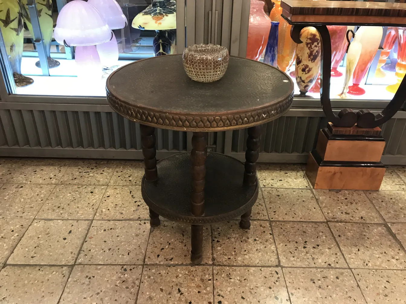 Tavolino antico decorativo con superficie rotonda e dettagli intagliati