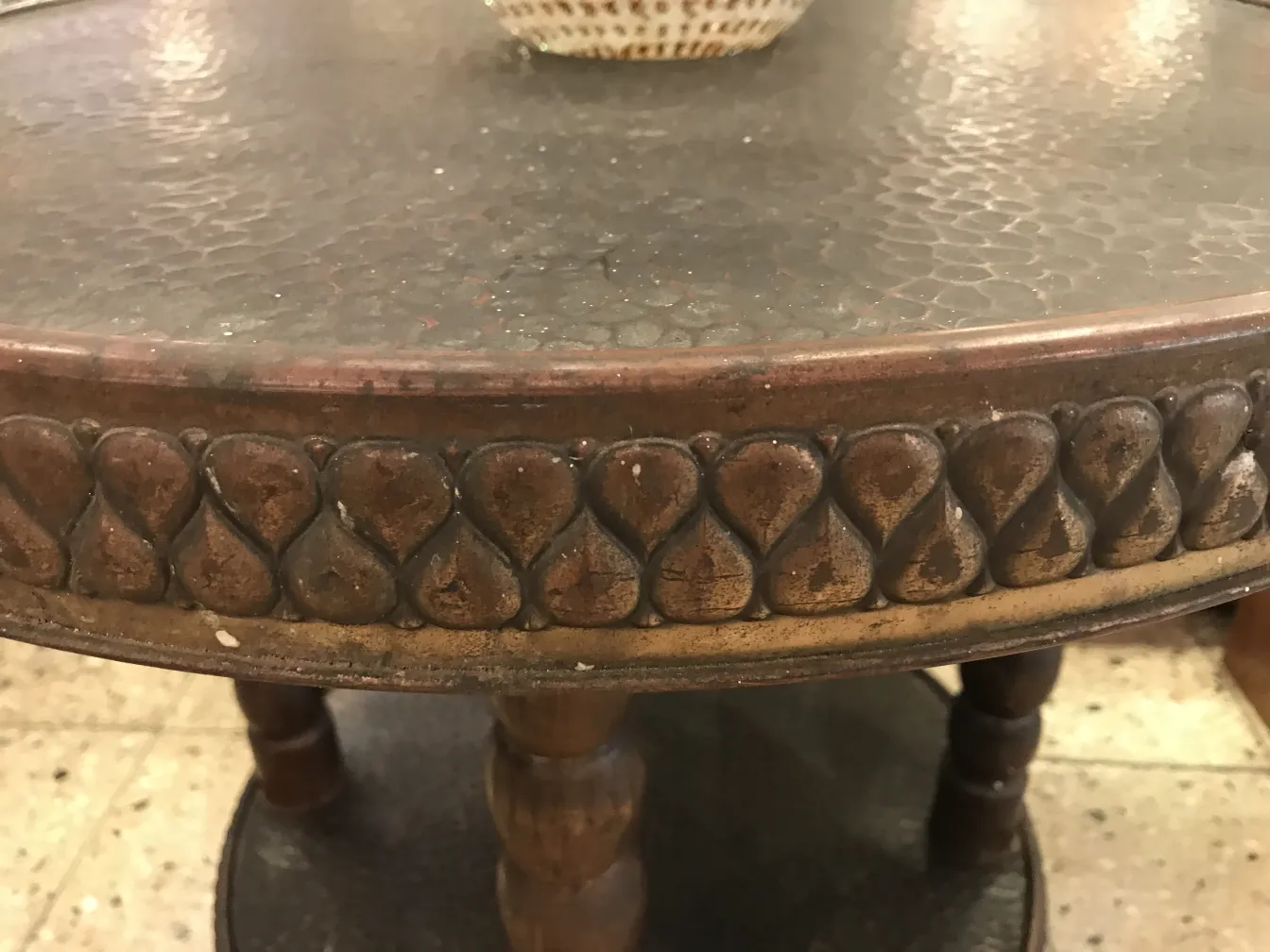 antique small table with decorative details on the bottom, vintage ambiance