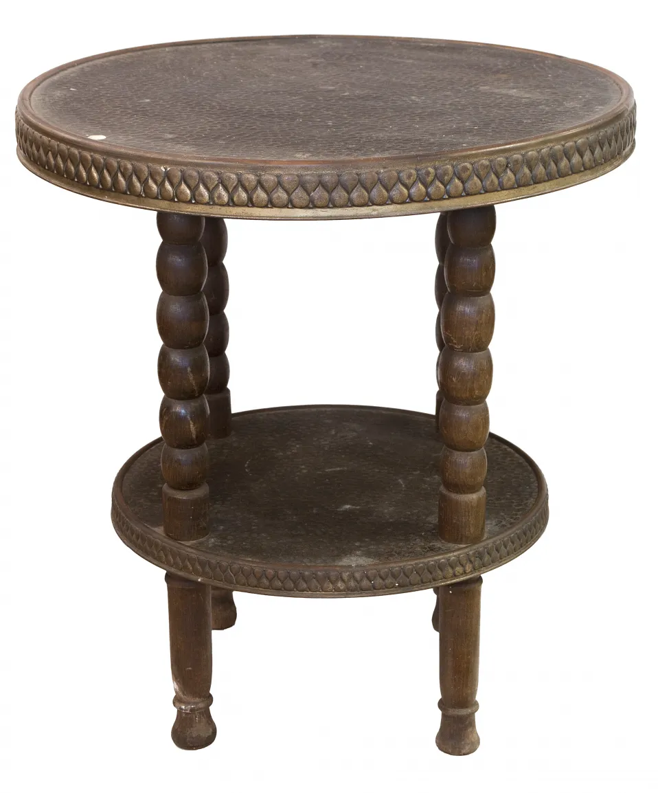 Старинный маленький столик с двумя уровнями, круглый дизайн и резные ножки в уютной обстановке.