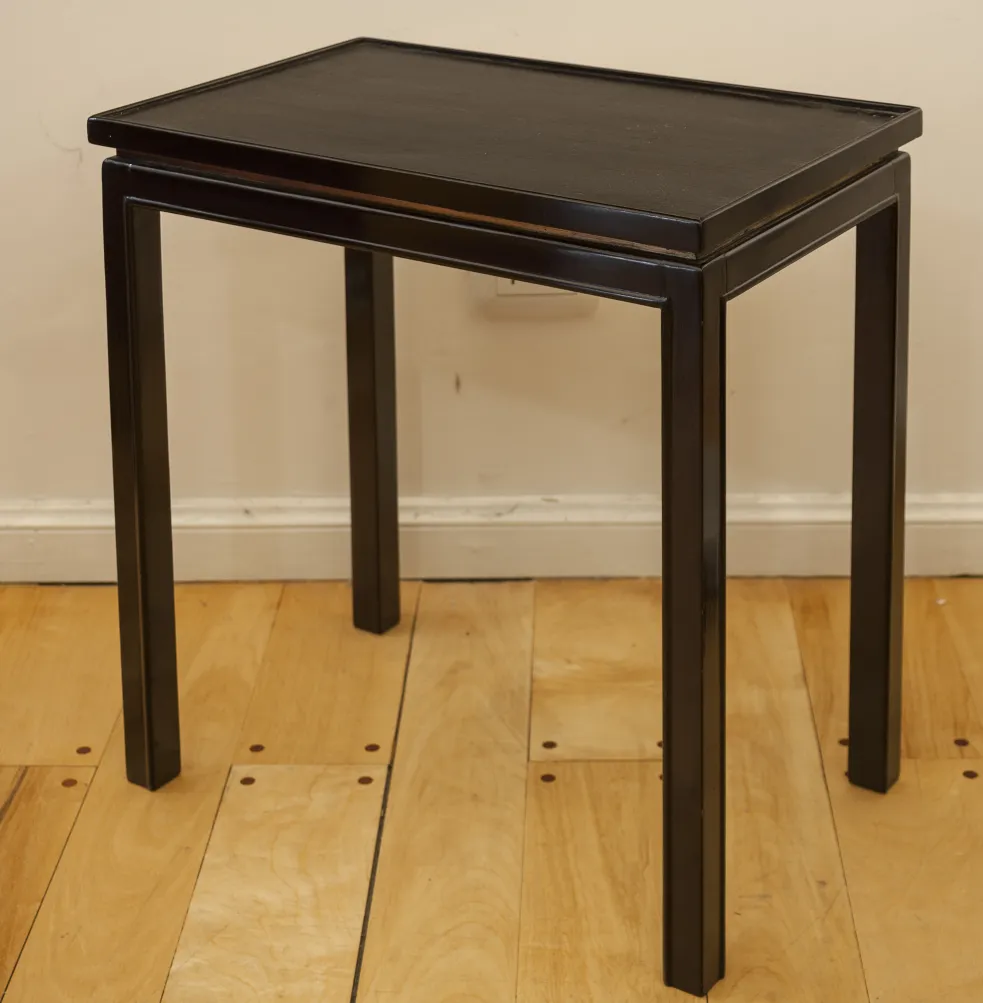 petite table antique sombre avec des pieds droits dans un cadre neutre