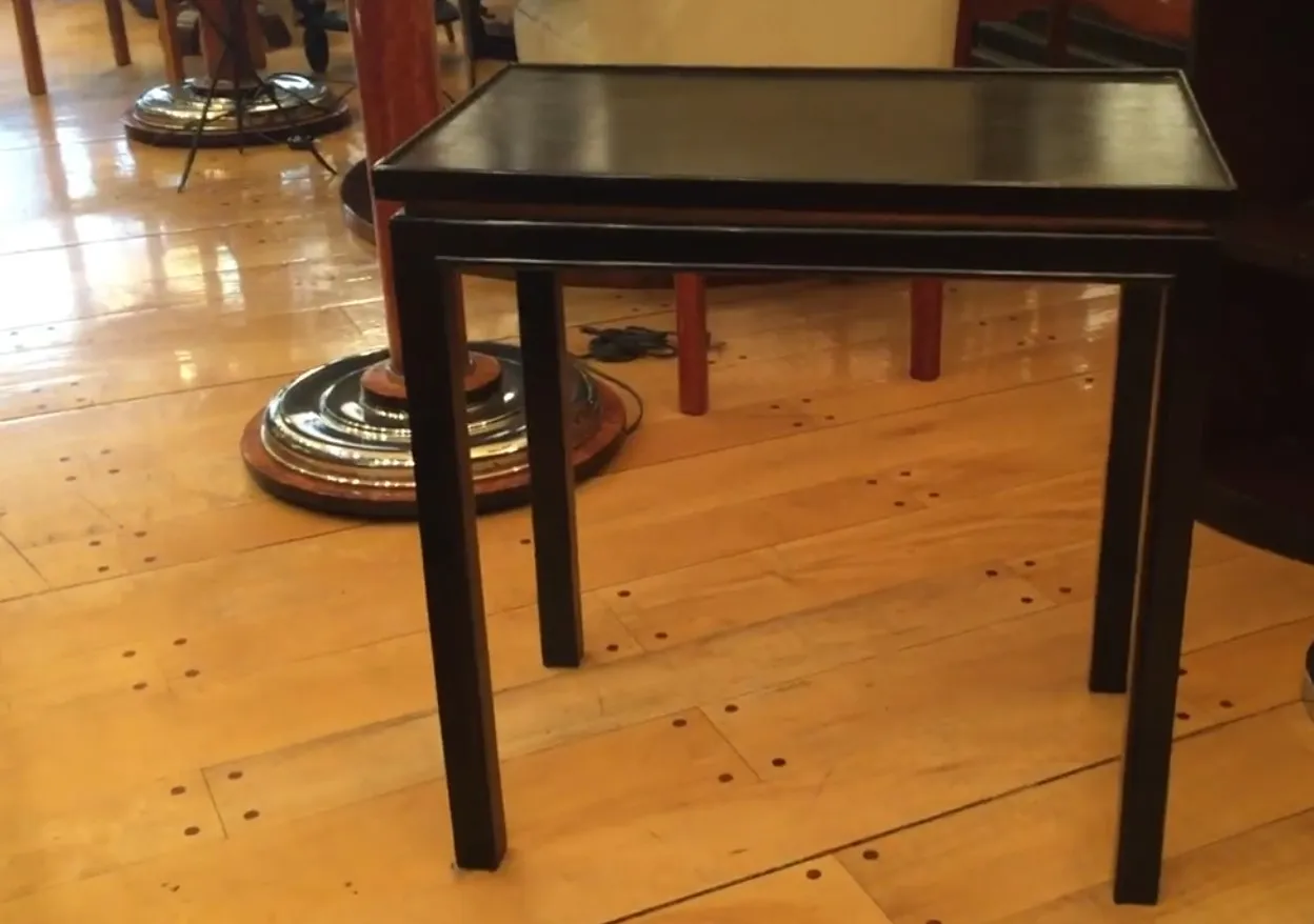 small antique black table with four legs in an environment