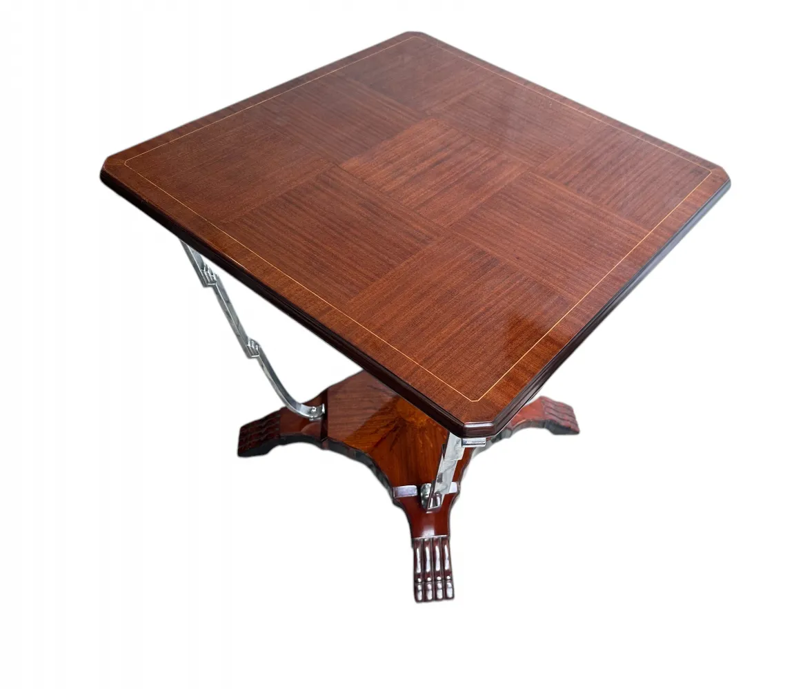 Petite table antique carrée avec détails décoratifs et base élaborée.