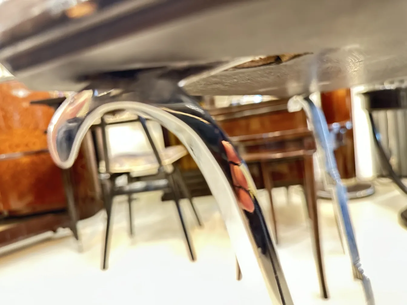 Ansicht der Basis eines antiken kleinen Tischs mit geschwungenen Beinen, Hintergrund mit anderen Möbeln