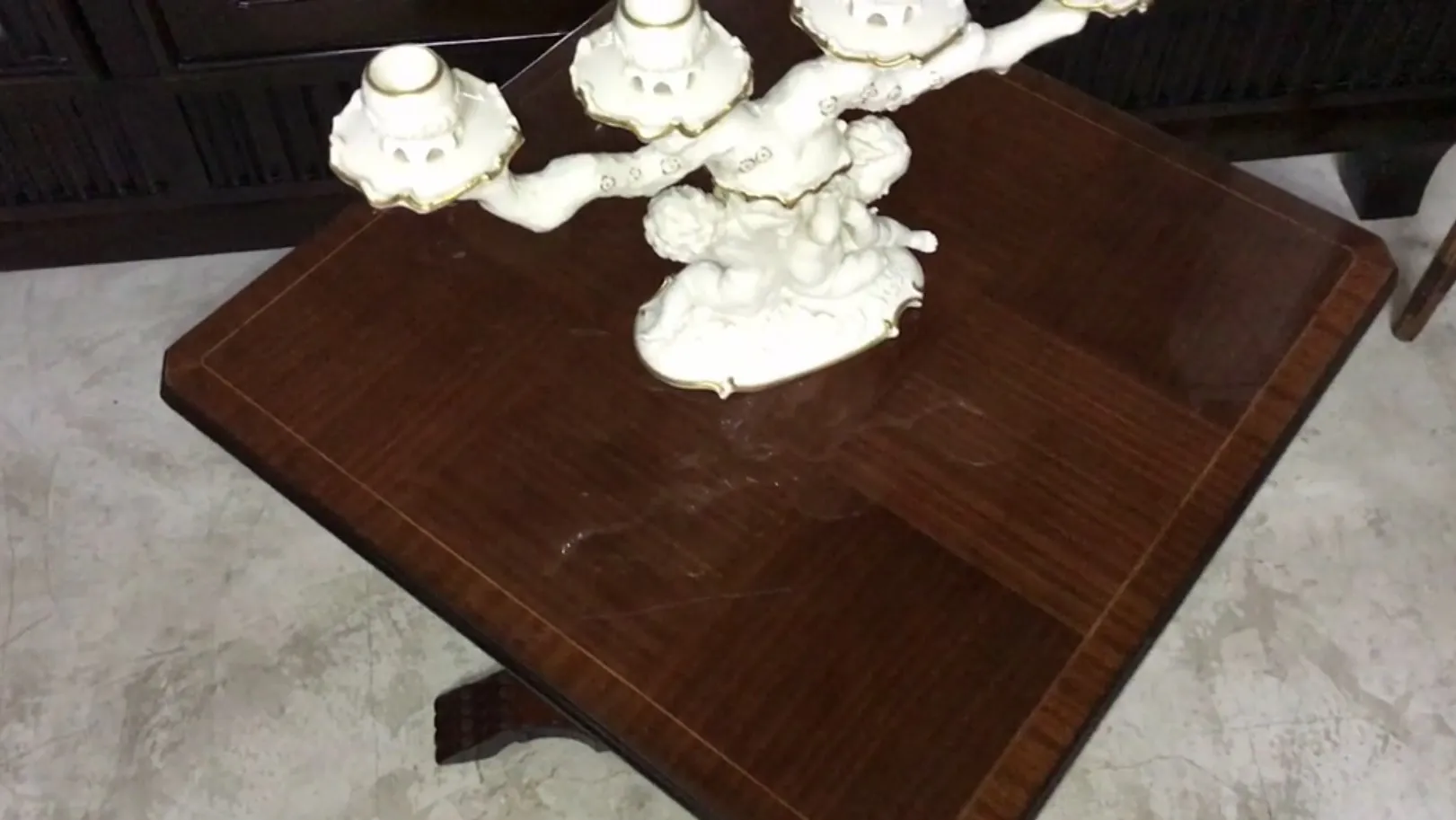 Mesinha antiga com um candelabro decorativo em cima