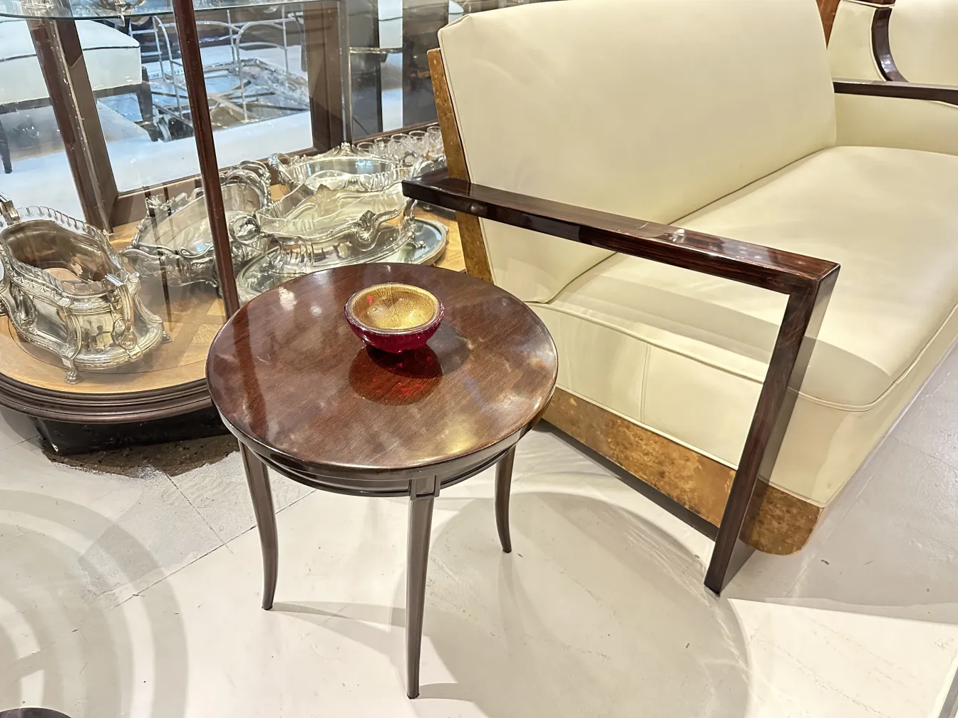 mesita antigua con un bol rojo encima en un ambiente elegante