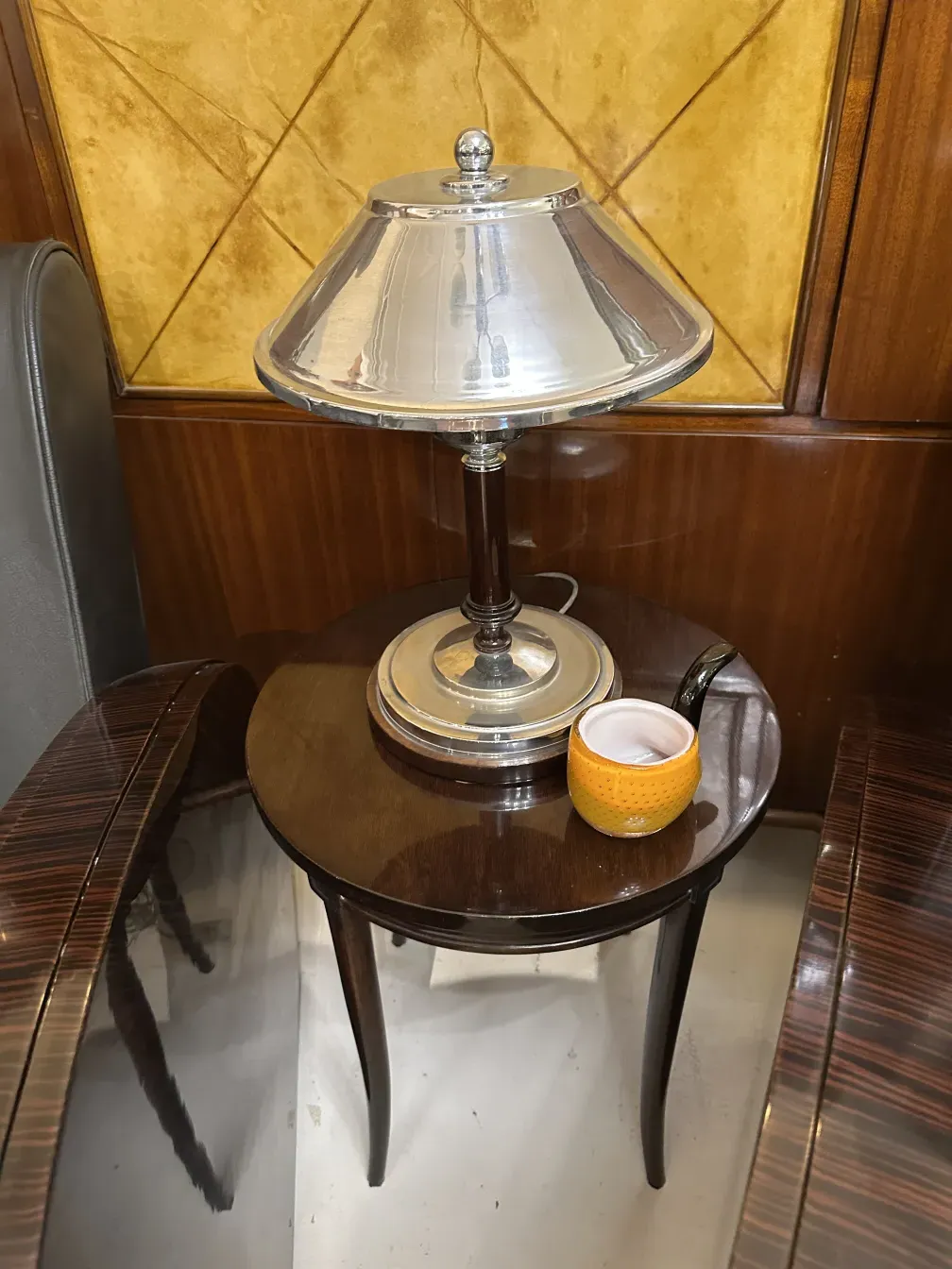 Antique small table adorned with a cover and a yellow decorative item.