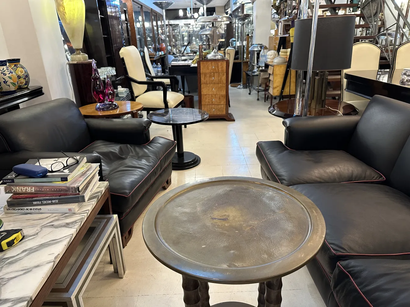 small antique table in a bright setting with dark sofas