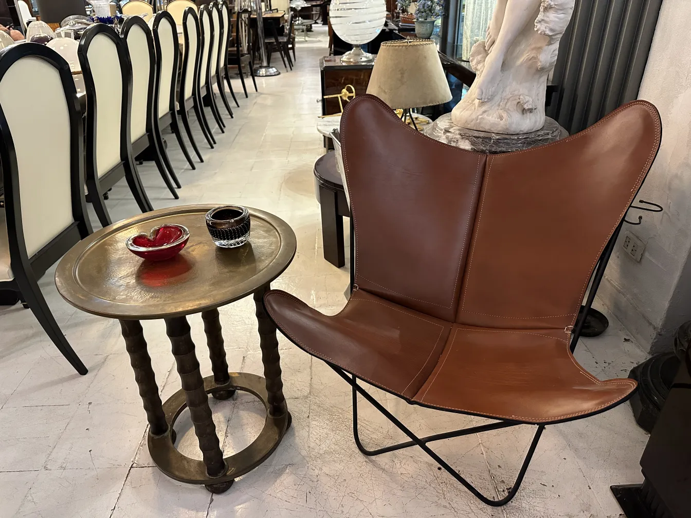 Mesita antigua con bandeja decorativa y patas torneadas en un entorno elegante.