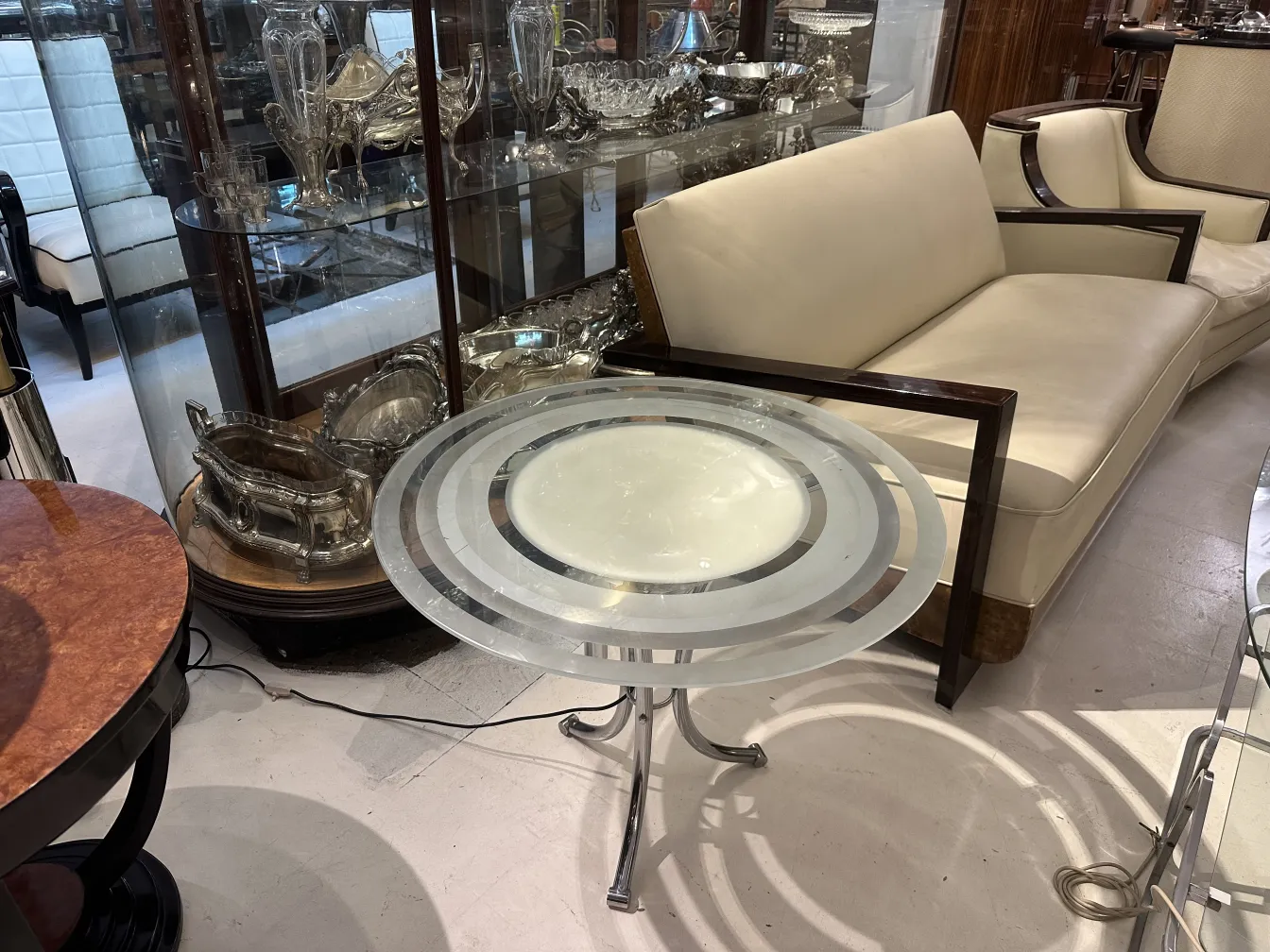 Petite table ancienne de salon avec design élégant et base distinctive dans un cadre classique.