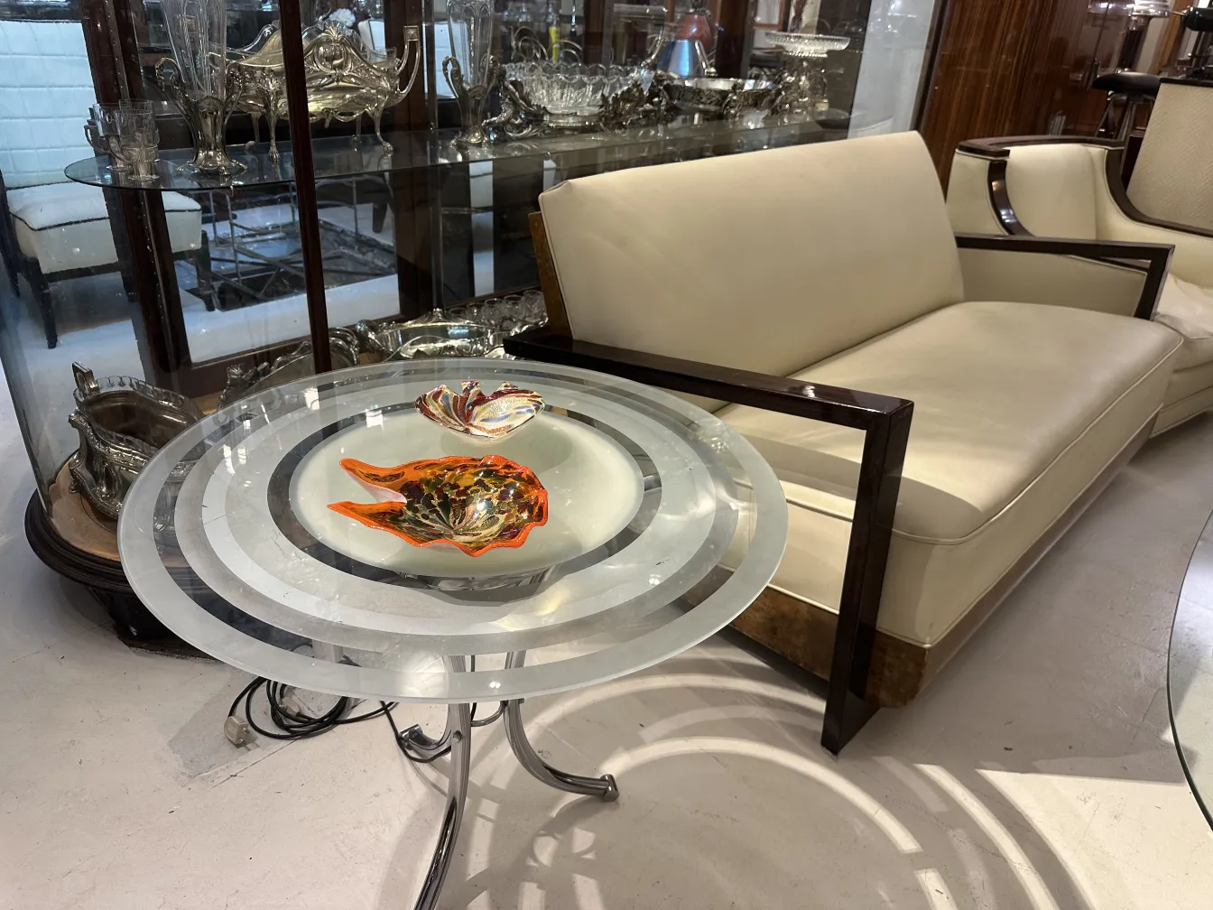 Tavolino antico con decorazioni colorate sopra, circondato da un ambiente elegante.