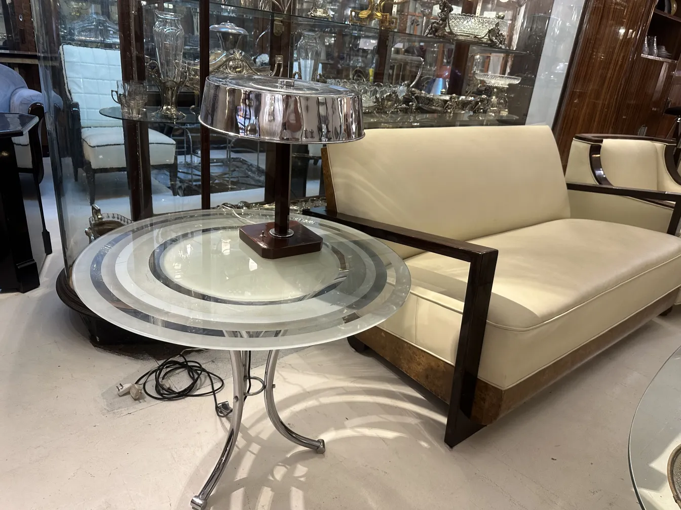 Mesinha antiga com design elegante e base de metal, em ambiente de sala.