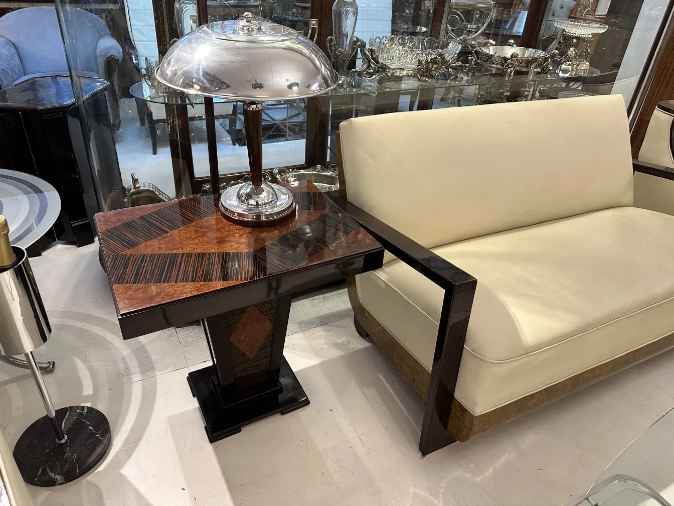 Tavolino antico con design elegante e lampada sopra, in un ambiente accogliente.