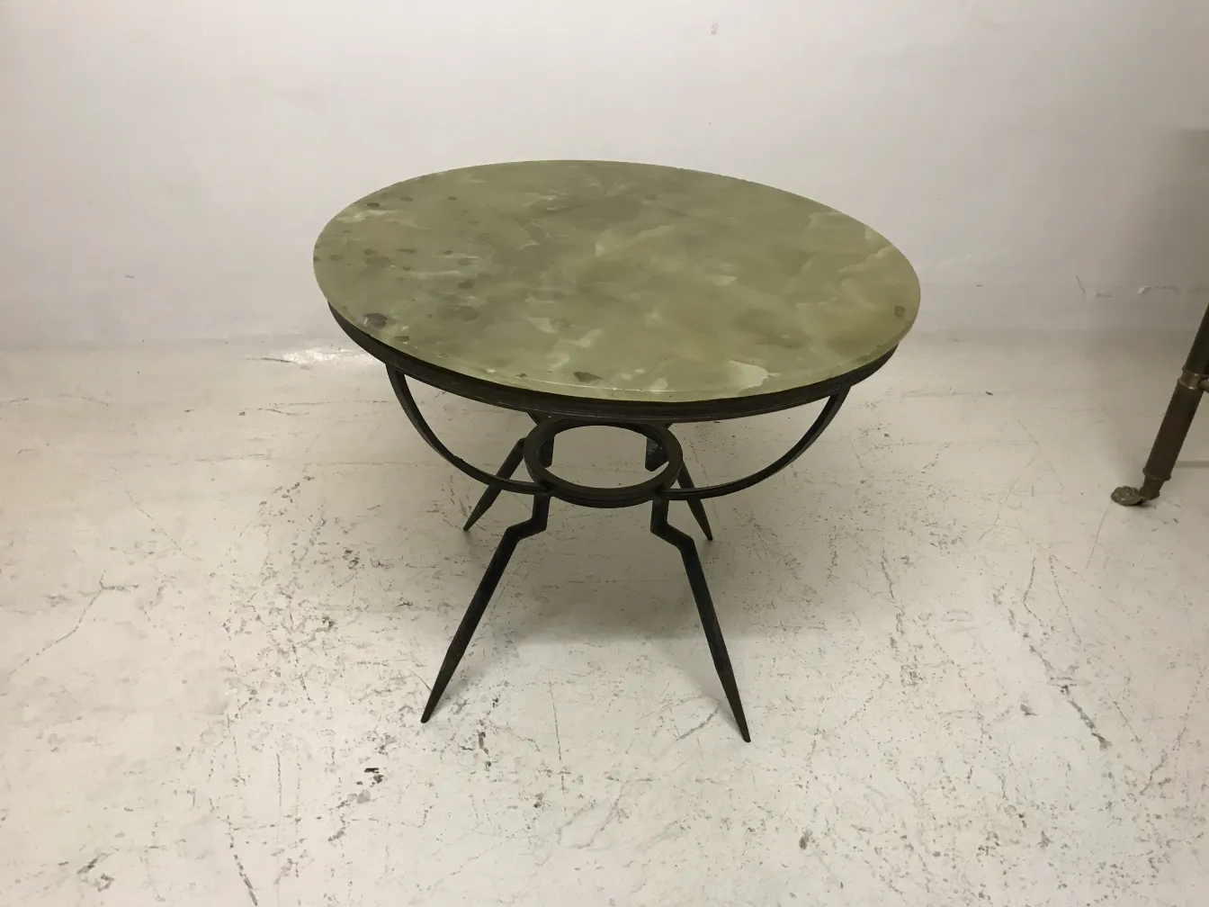 antique round small table with black base in room