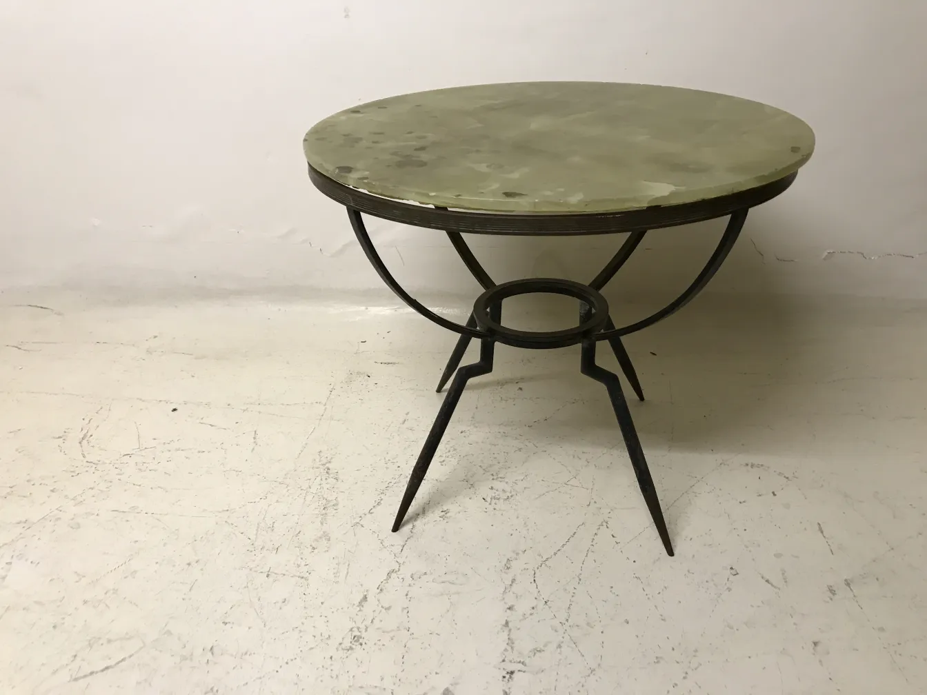 Round small table with slender legs on a light background.