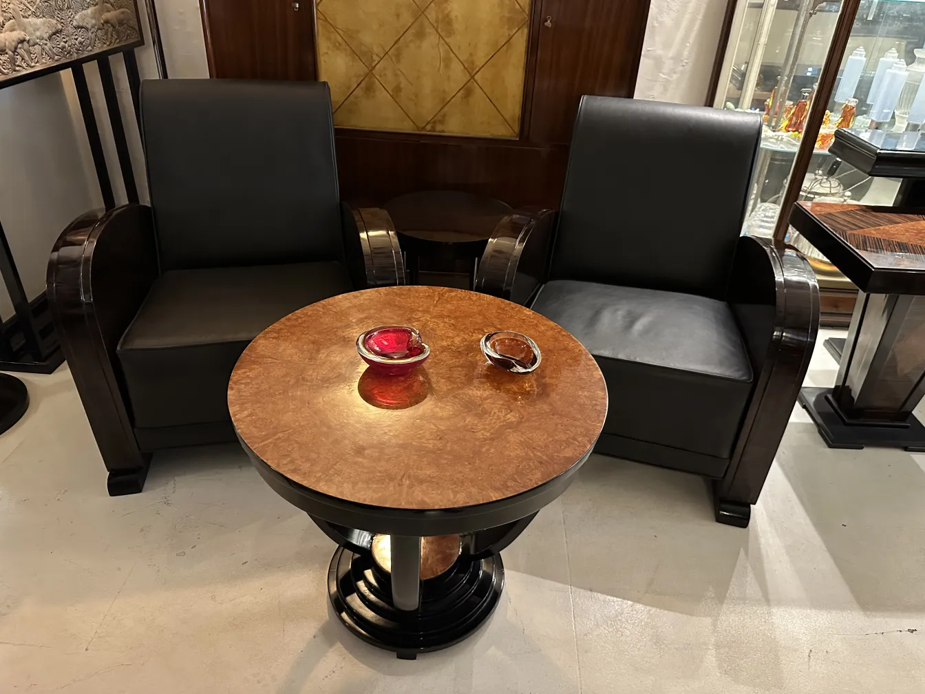 पुरानी छोटी मेज़ और दो काले गद्दियाँ