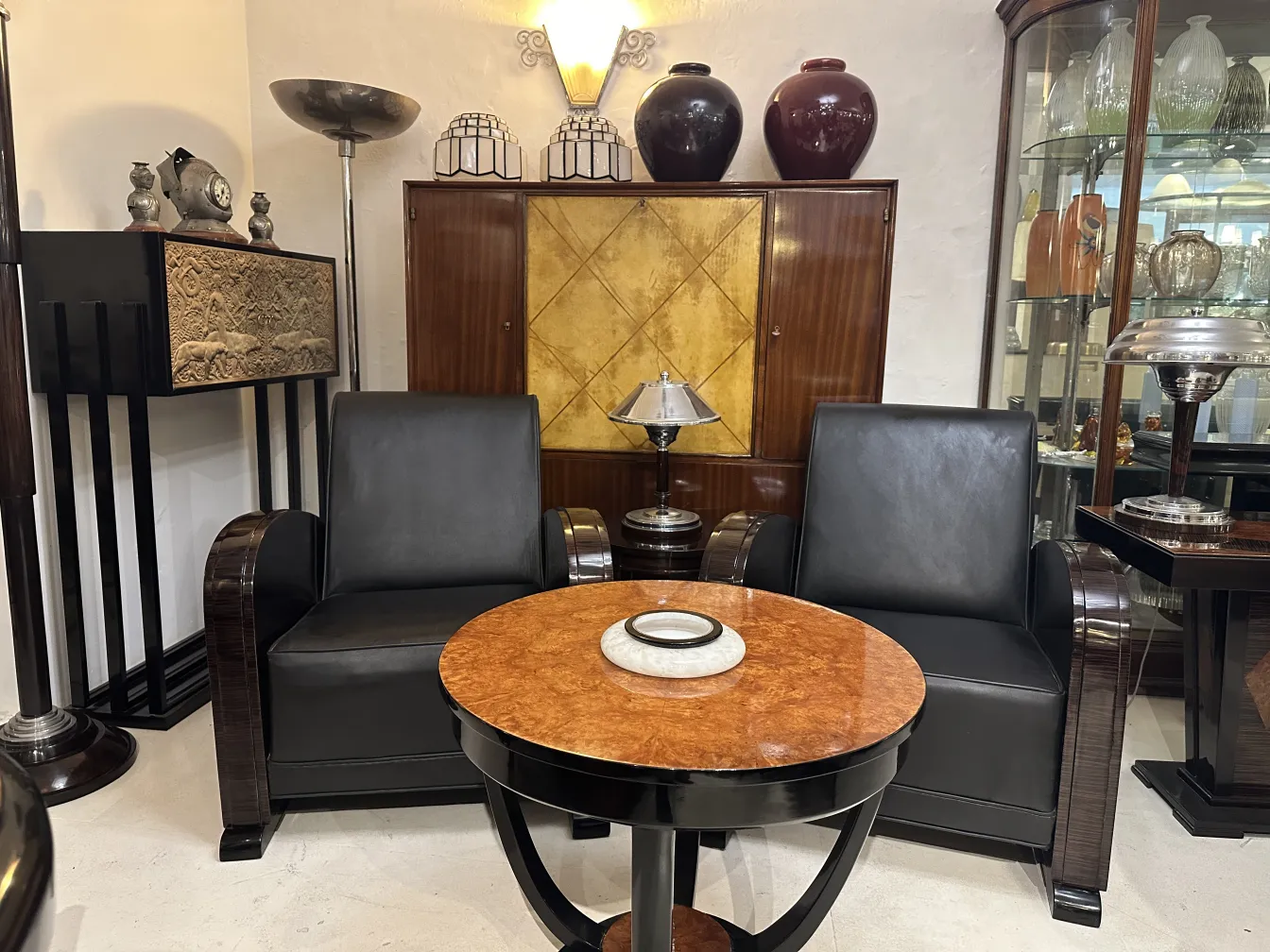 alter kleiner Tisch im Wohnzimmer mit schwarzen Stühlen und Dekoration