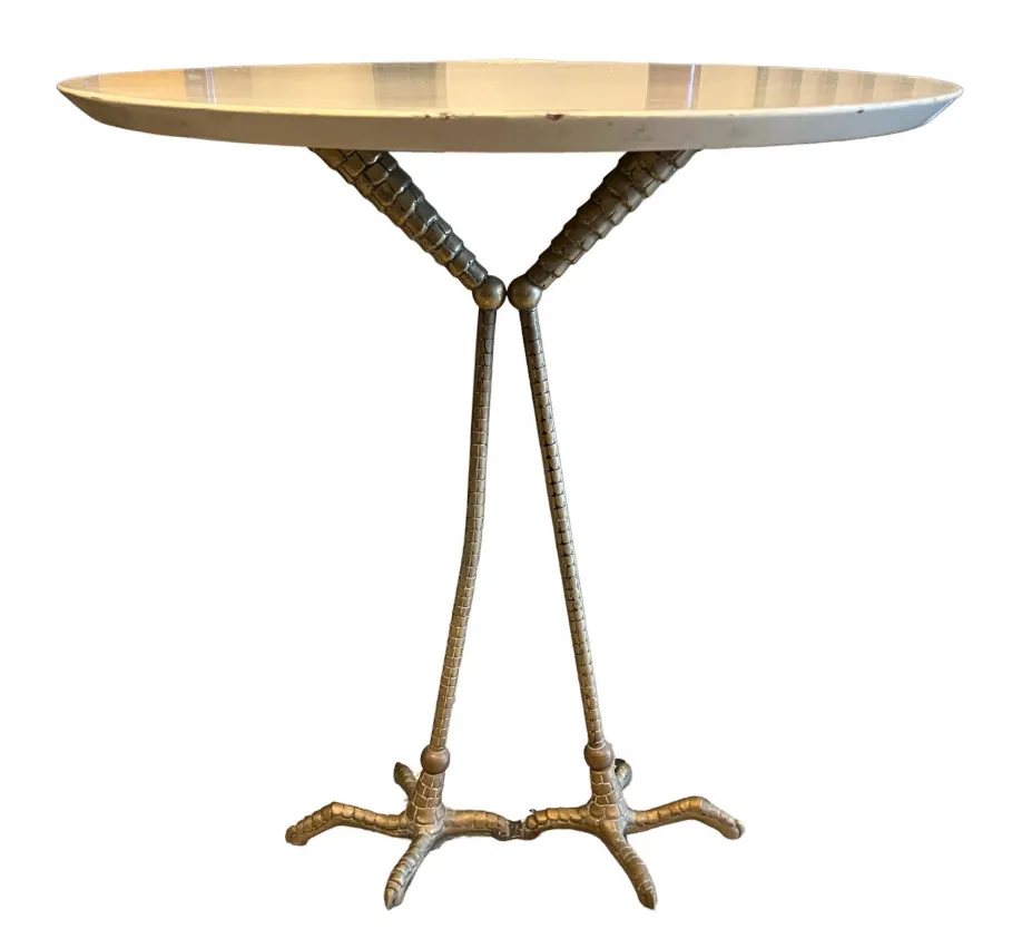 Mesa antigua de forma ovalada con una base inusual, decoración elegante.