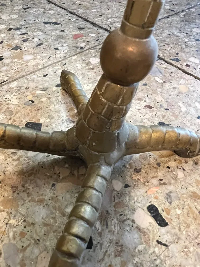 Base of an antique table with decorative golden legs.