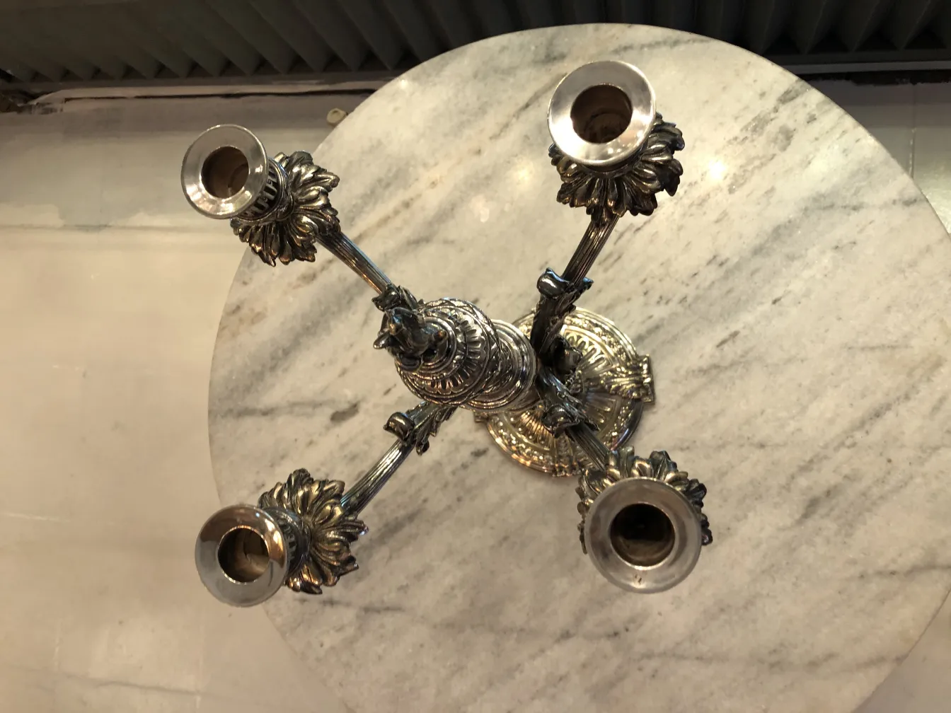 deux candélabres anciens avec des détails décoratifs sur une table en marbre