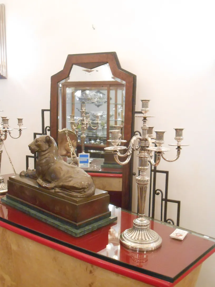 दो पुरानी कैंडेलब्रा art nouveau सुरुचिपूर्ण डिजाइन के साथ, एक सजावटी आकृति के बगल में।