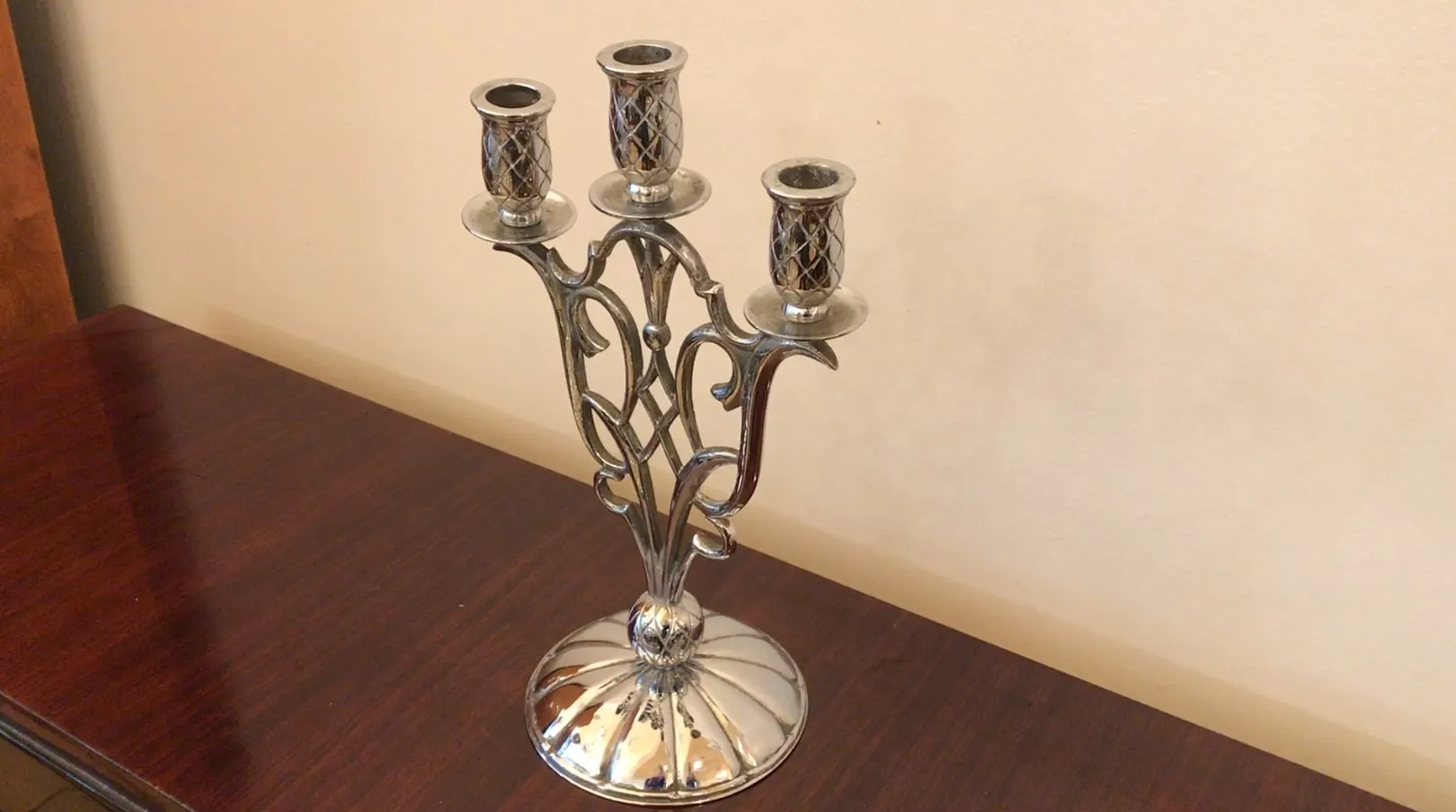 Candelabri dal design elegante con tre braccia in un ambiente antico