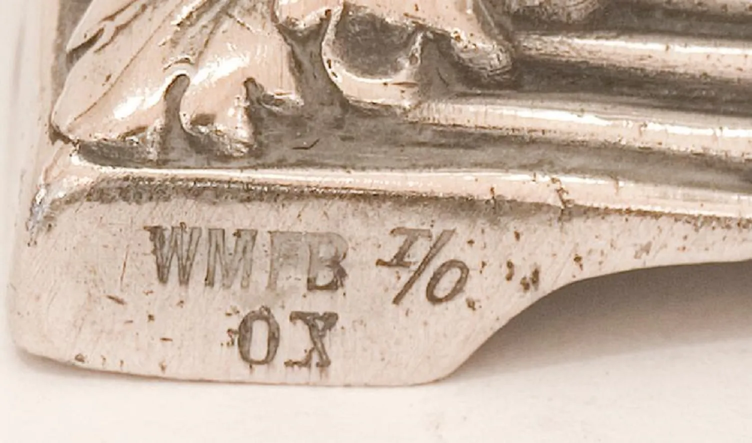 Seitenansicht von zwei antiken Kerzenhaltern art nouveau vor einem neutralen Hintergrund.