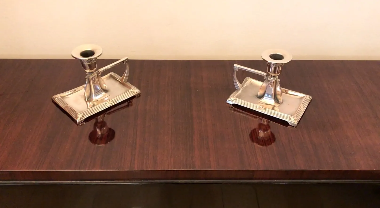 dos candelabros antiguos art nouveau en una mesa de madera