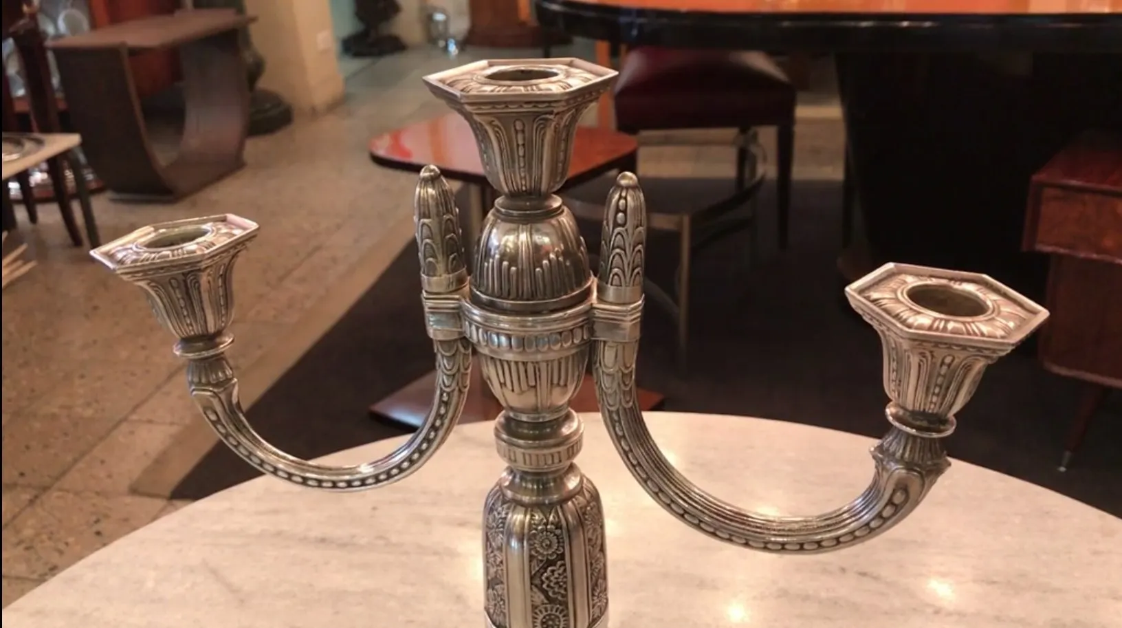 two antique candelabras with decorative designs