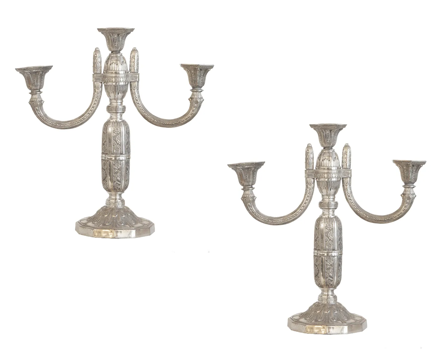 2 antique candelabras with elegant arms on a table